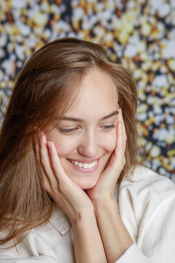 Mujer sonriendo y tocando su cara después de un peeling facial en Madrid